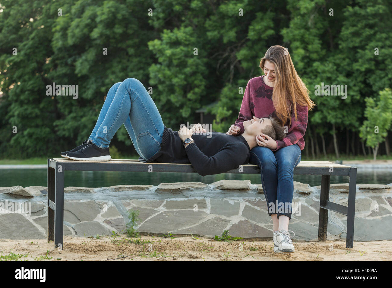 Gesamte Länge der Mann liegt auf Schoß der Freundin im park Stockfoto