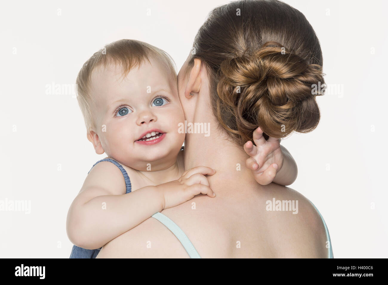 Rückansicht der Mutter tragen glückliches Mädchen vor weißem Hintergrund Stockfoto