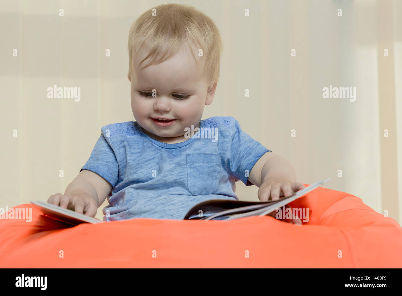 Nahaufnahme von niedlichen lächelndes Mädchen Buch sitzend auf Sitzsack zu Hause Stockfoto