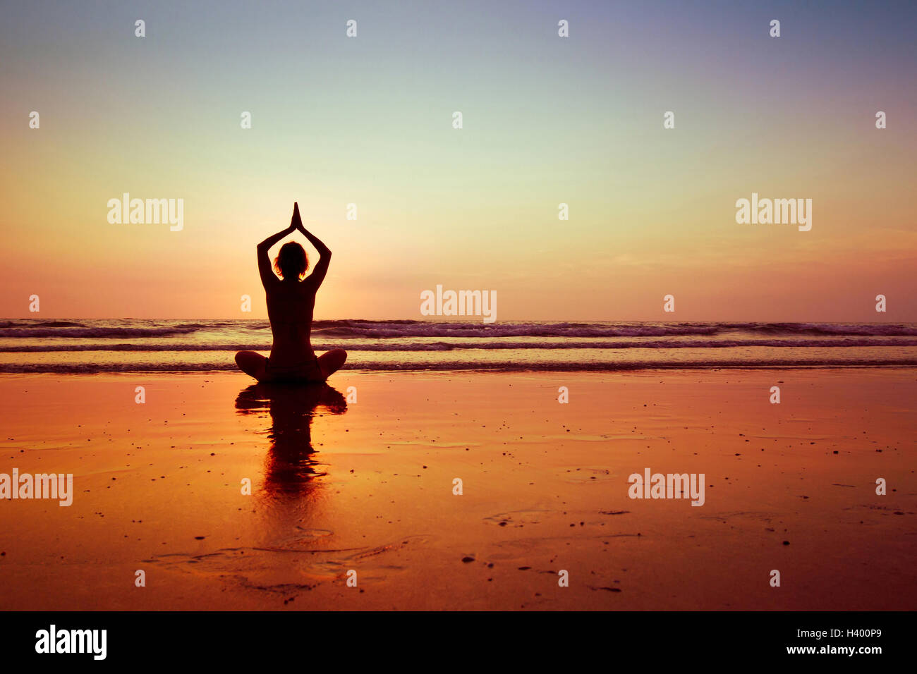 Frau praktizieren Yoga am Strand bei Sonnenuntergang in Koh Chang, Thailand Stockfoto