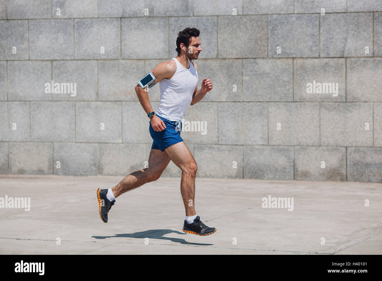 Ermittelten Sportler Joggen auf Bürgersteig von Mauer Stockfoto