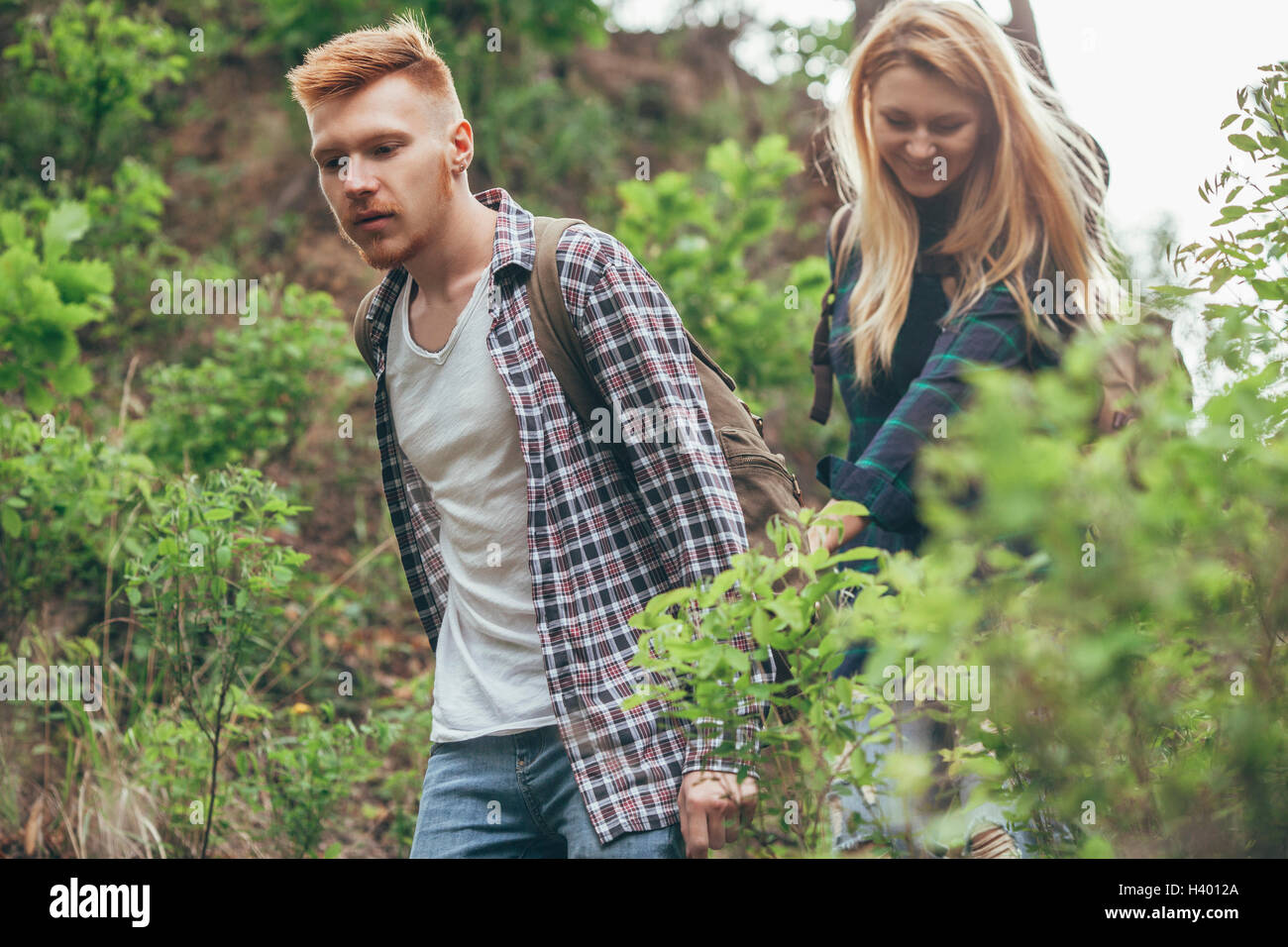 Junges Paar wandern inmitten von Pflanzen im Wald Stockfoto