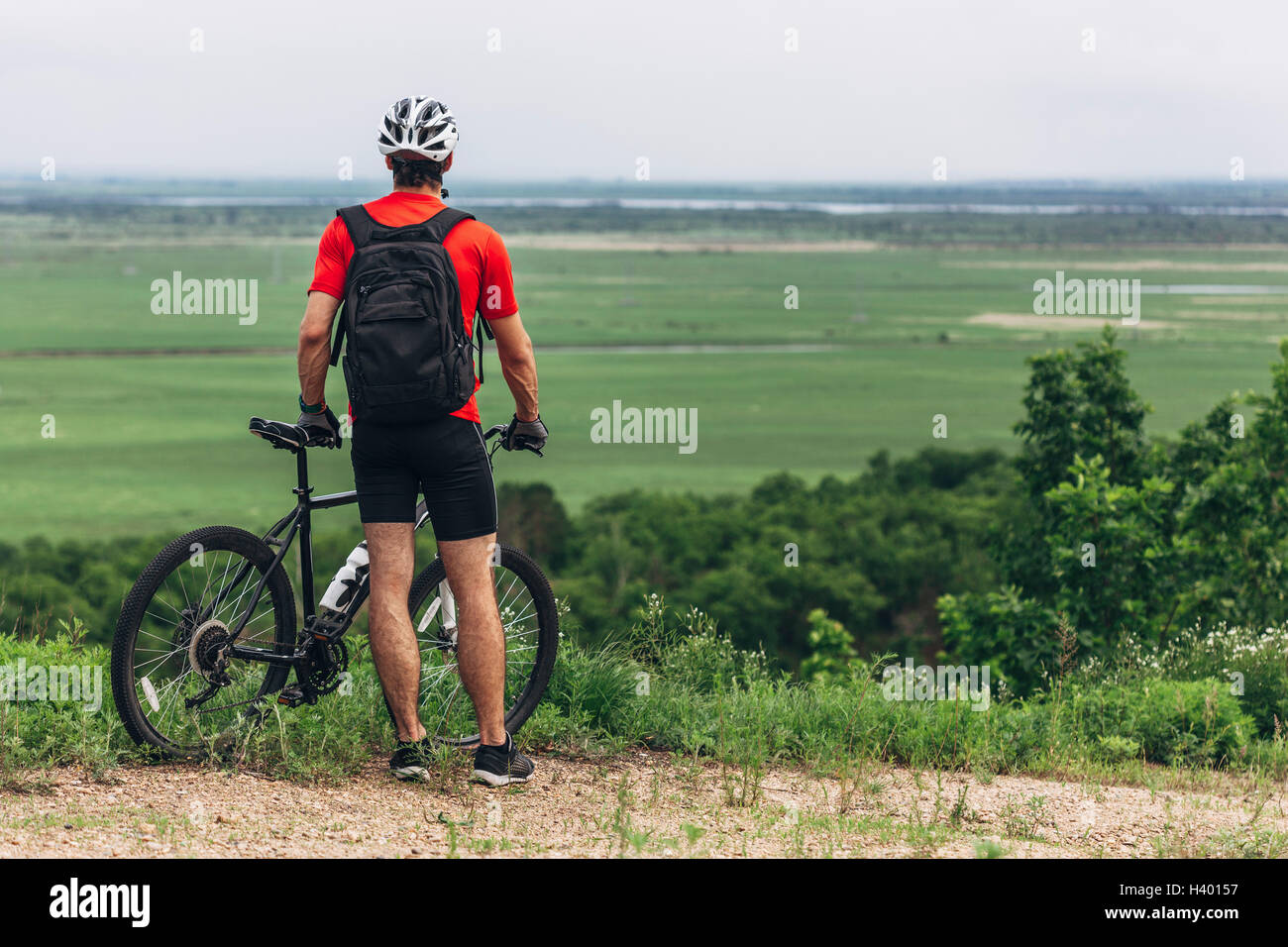 Rückansicht des Mannes mit Mountain Bike stehend auf Hügel Stockfoto