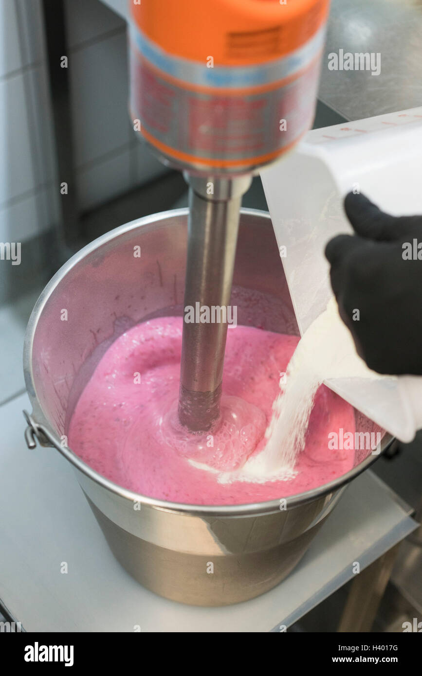 Detail von Hand mischen Zutat in Erdbeereis in Maschine Stockfoto