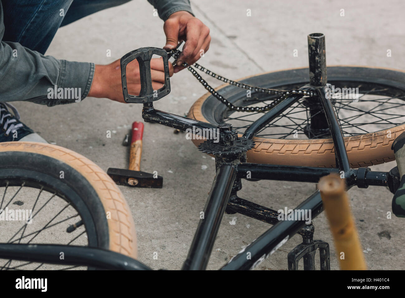 Detailansicht eines Teenagers Reparatur Fahrradkette Stockfoto