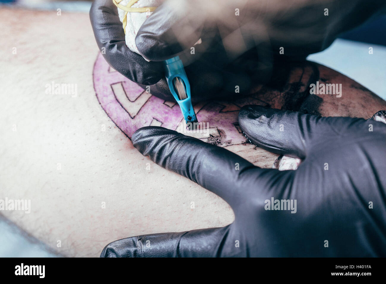 Künstler tätowieren Design auf der menschlichen Haut im studio Stockfoto