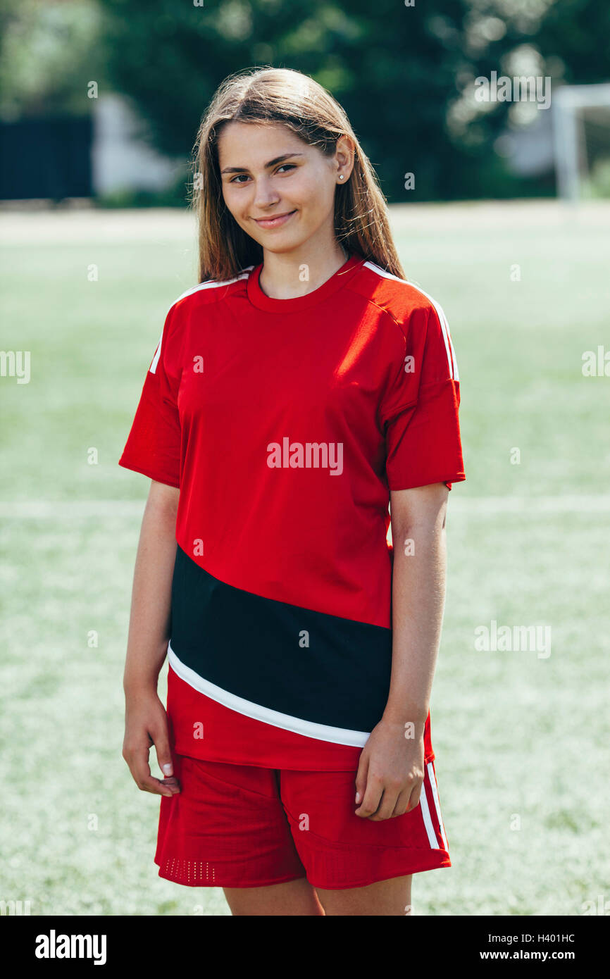 Porträt von fröhlichen Teenager Fußballspieler auf Feld stehen Stockfoto