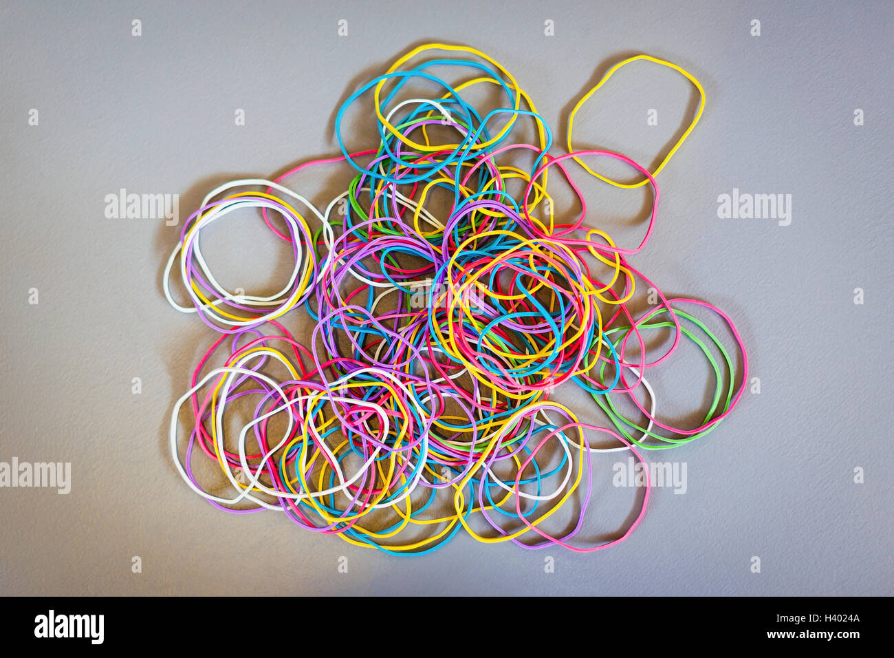 Direkt über dem Schuss von Multi farbige Gummibänder auf grauem Hintergrund Stockfoto