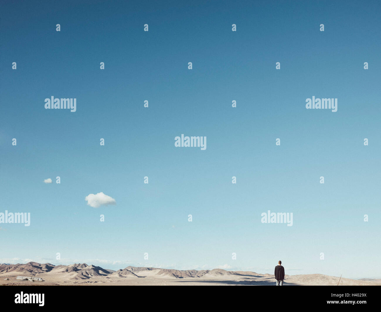 Rückansicht des Mann auf kargen Landschaft gegen blauen Himmel, San Bernardino, Kalifornien, USA Stockfoto