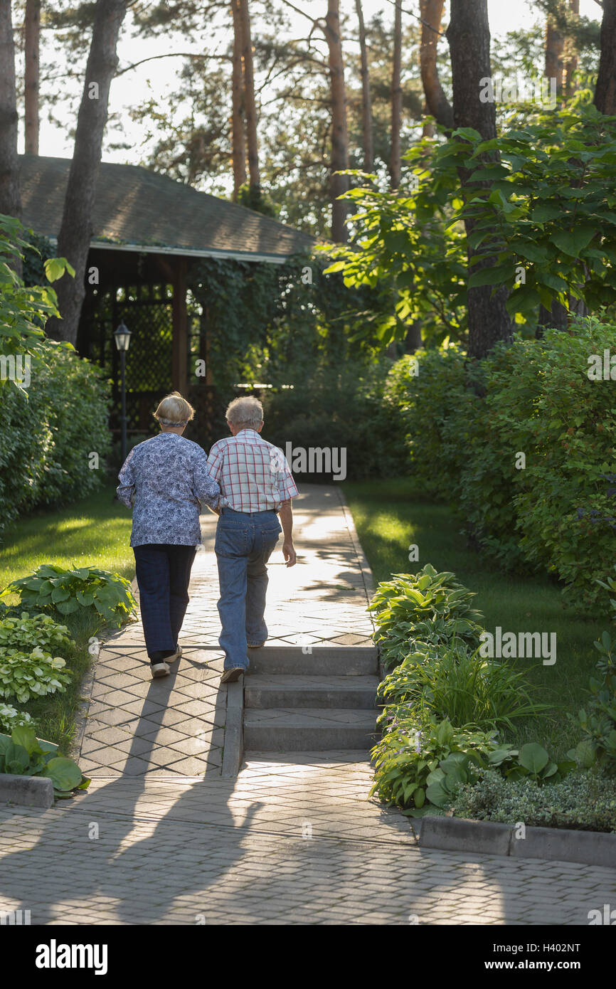 Rückansicht des Paares zu Fuß in Richtung Haus inmitten von Pflanzen Stockfoto