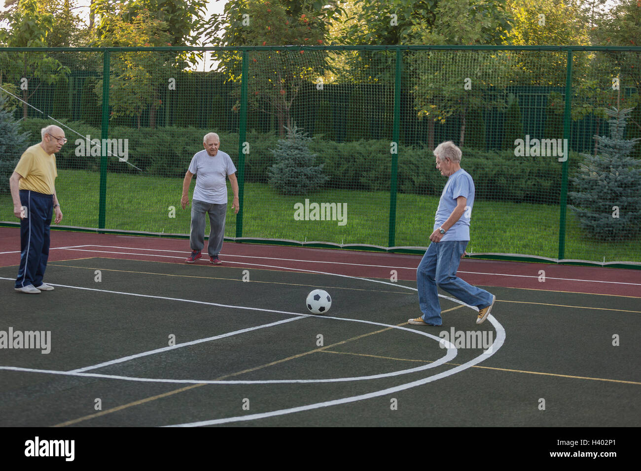 Senioren Freunde von Zaun im Bereich Fußball spielen Stockfoto