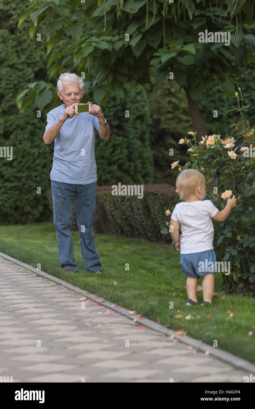 Großvater fotografieren Mädchen berühren stieg im park Stockfoto