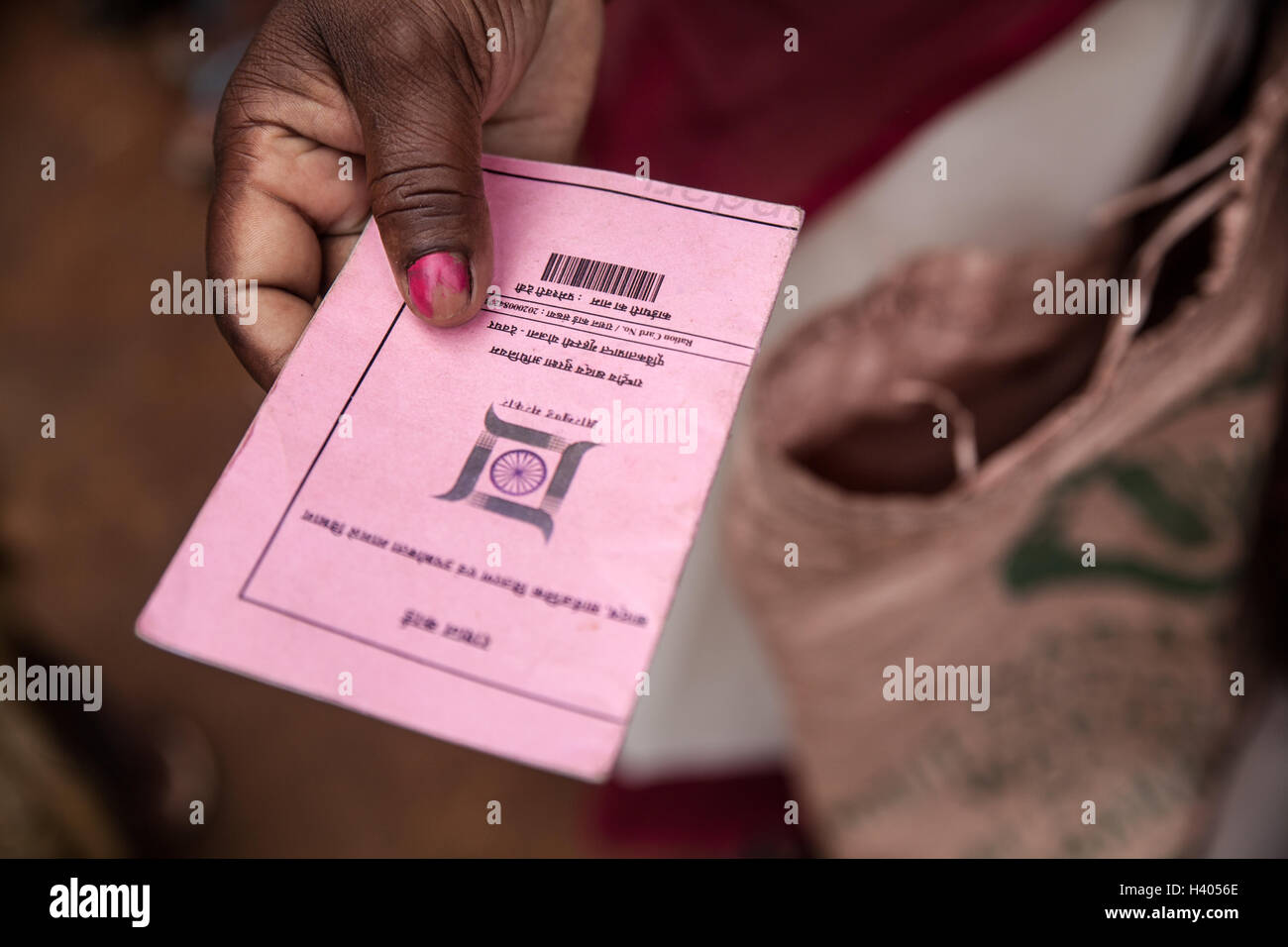 Hand einer Frau zeigt ihre Rationierungskarte, die ihr erlaubt, kaufen, hoch subventionierten Reis nach der nationalen Ernährungssicherheit A Stockfoto
