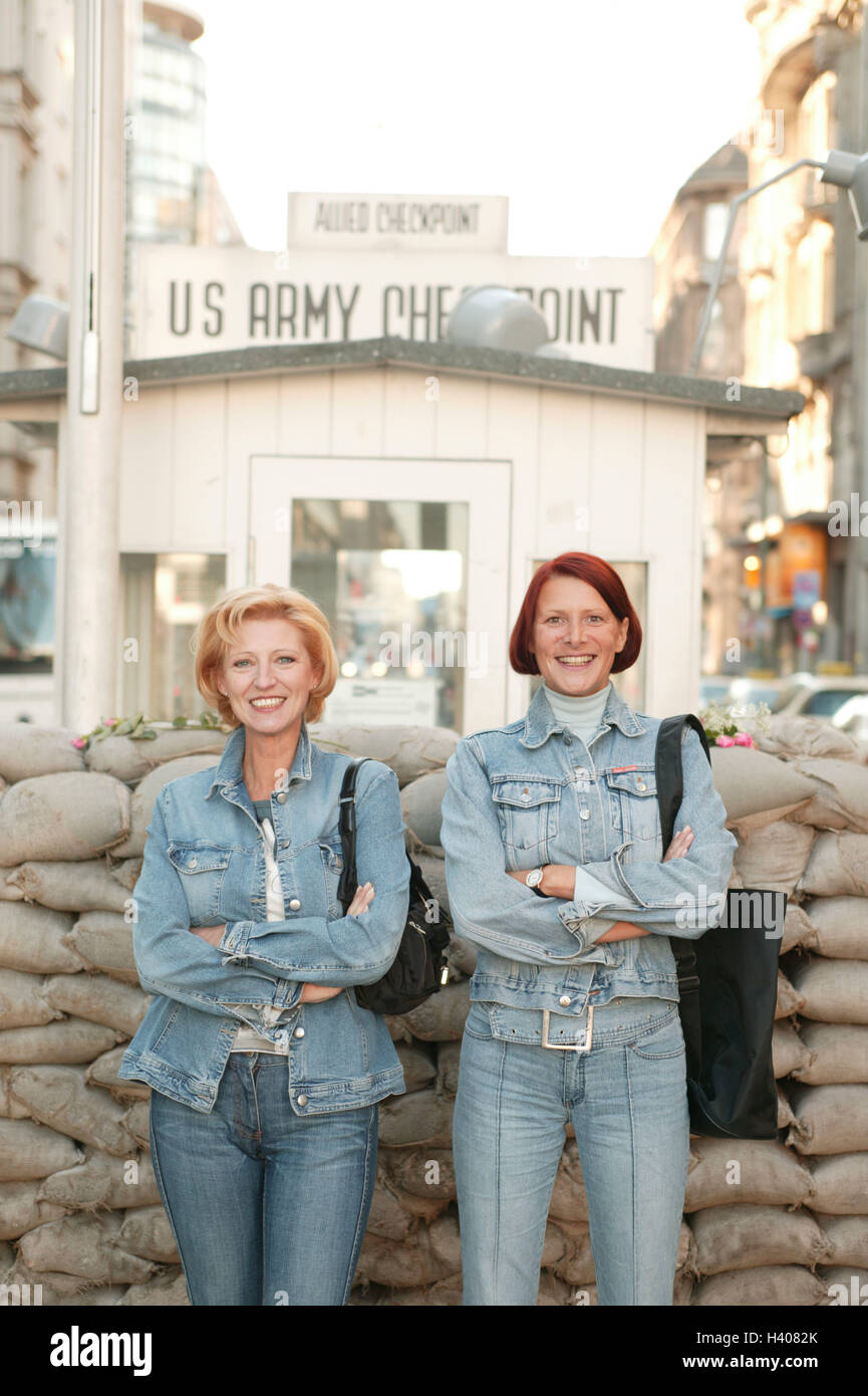 Deutschland, Berlin, Checkpoint Charlie, Säcke, gestapelt, Touristen, Lächeln, Kreuz, Europa, Stadt, Hauptstadt, Innenstadt, Teil Stadt, Geschichte, Kultur, Kriegsgeschichte, amerikanischen Sektor, ehemaligen, der DDR, der US-Armee, Sandsäcke, Chargen, Ort von Interesse, Frauen, zwei Freunde, mittlerer 40-50 Jahre alte Person, Geste, Arme, Selbstvertrauen, Selbstbewusstsein, Fröhlichkeit, Reisen, Städtereisen, Sehenswürdigkeiten Stockfoto