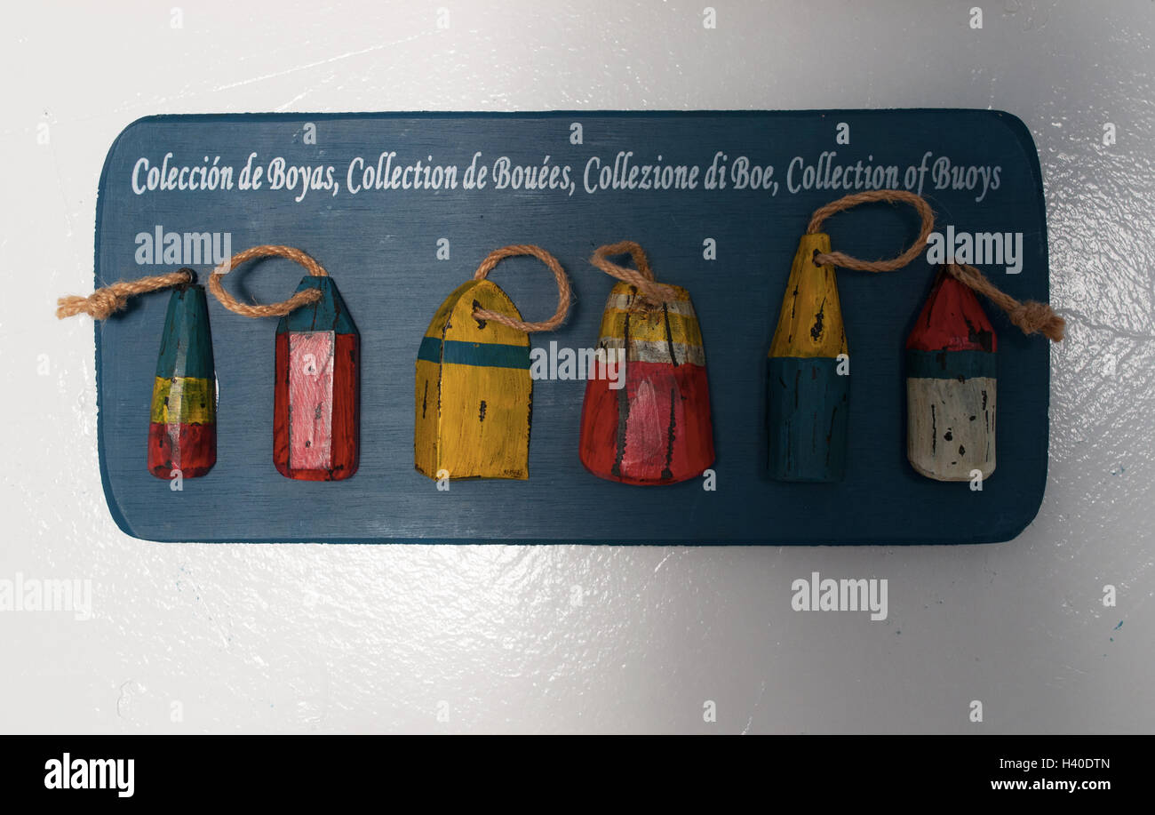 Inneneinrichtung: Holzplatte mit einer Sammlung von Bojen und Schwimmer für die Fischerei auf einer weißen Wand Stockfoto