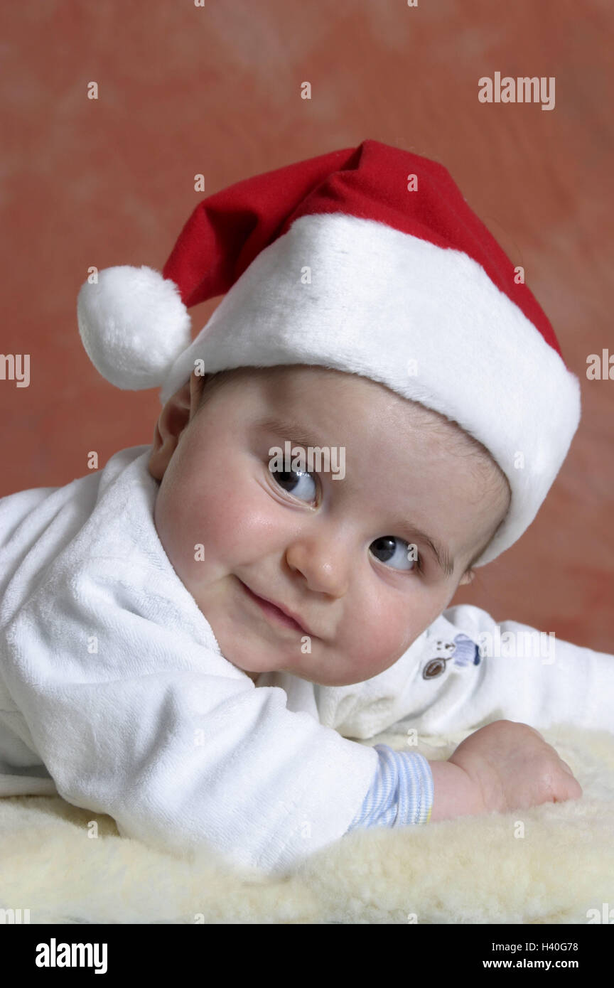 Weihnachten, Baby, die Weihnachtsmütze, Lügen, Lammfell, Porträt, 6 Monate, Kind, Baby, Mädchen, Lächeln, unbeschwerte Kindheit zu kitzeln, spielen, spielerisch, Neugier, innen, Advent, Yule Flut, Weihnachtszeit, für Weihnachten Stockfoto