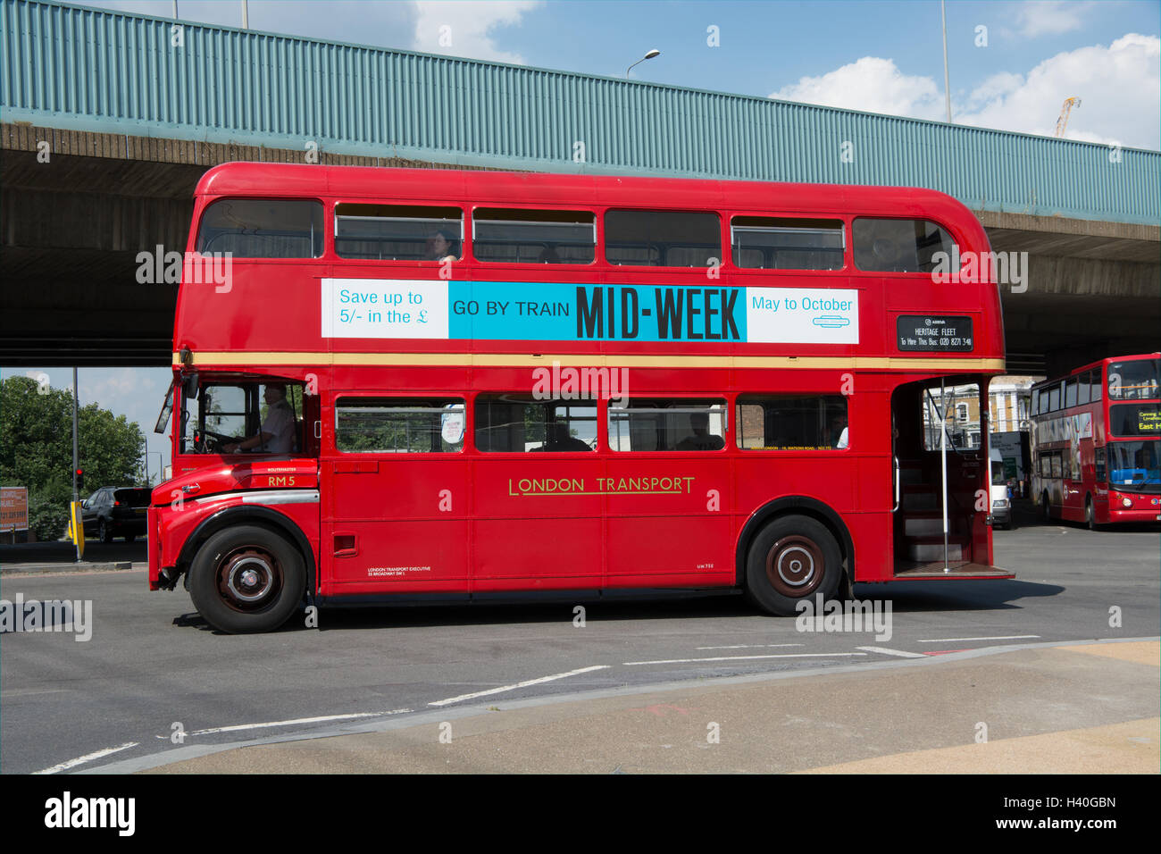 In der Nähe von Seitenansicht eines klassischen AEC Routemaster Bus in London Transport Lackierung zu unterqueren die Hochstraße Canning Town Stockfoto