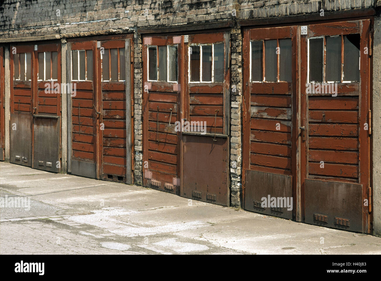 Innenhof, Garagen, hölzerne Tore, verwitterte, Straße, Teer, Asphalt, Risse, Gericht, Garage-Serie, Garagentore, Garagentore, Tore, aus Holz, Ebenen, Lacke, Farbe, Peel off, Zerfall, vergänglich, Vergänglichkeit, Renovierung-mittellos, p Stockfoto