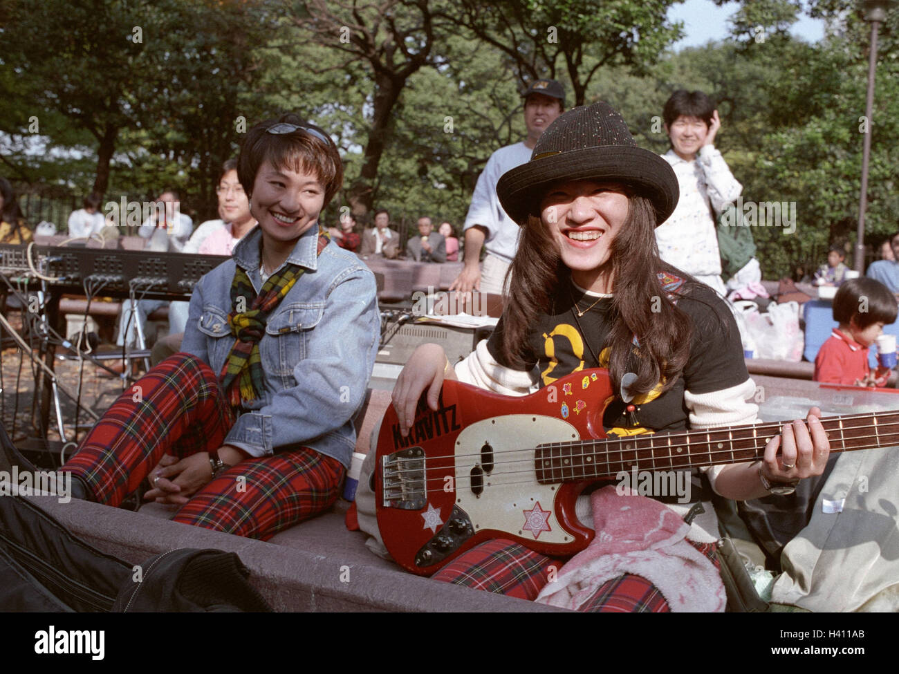 Japan, Honshu, Tokio, Park, Veranstaltung, Besucher, Mädchen, Gitarre, keine Modellfreigabe!, außen, Tokyo, Musikveranstalltung, Festival, Konzert, Frauen, jung, Musiker, Künstler, glücklich, Bänke, Sitz Gelegenheiten, sitzen, warten, Teenager, Jugendliche, Schülerinnen, Düsseldorfer Stockfoto
