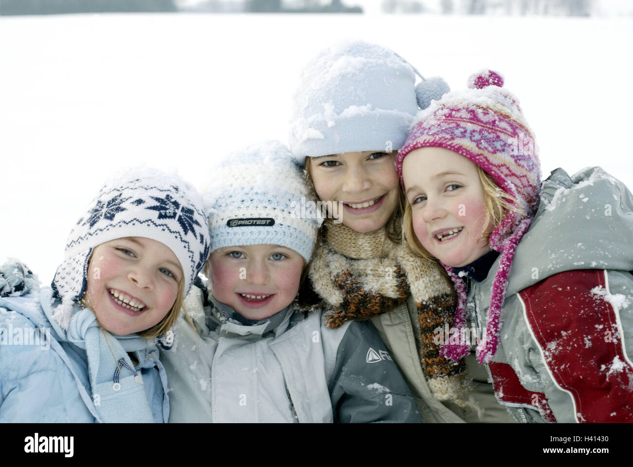 Mädchen, Lächeln, Winterkleidung, Gruppenbild, Porträt, Saison, Winter, Winterspass, Kinder, Kindheit, Freunde, vier, glücklich, Fröhlichkeit, Schnee, Spaß, Freude, Fröhlichkeit, Winterkleidung, Schnee Kleidung, Abwehrkräfte, Rückfahrkamera, Kind Portrait, Mützen, Kopfbedeckungen Stockfoto