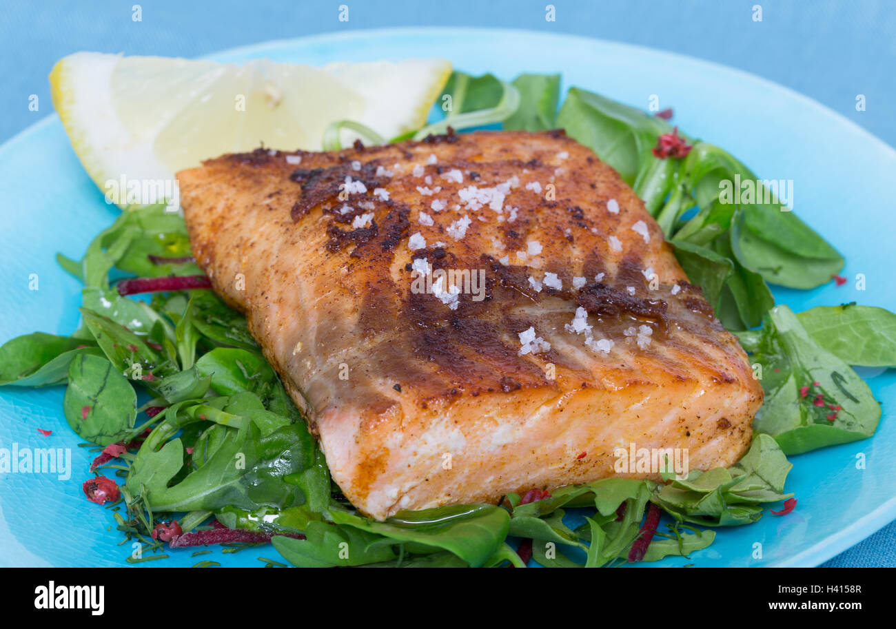 Gebratener Lachs-Filet mit Fleur de Sel auf gemischtem Salat. Stockfoto
