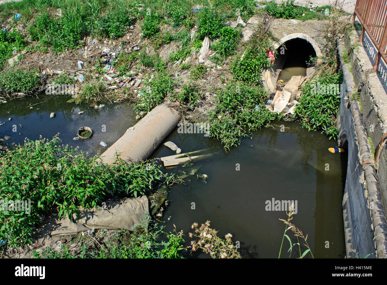 Sehr verschmutzten Fluss, der durch das Dorf fließt. Stockfoto