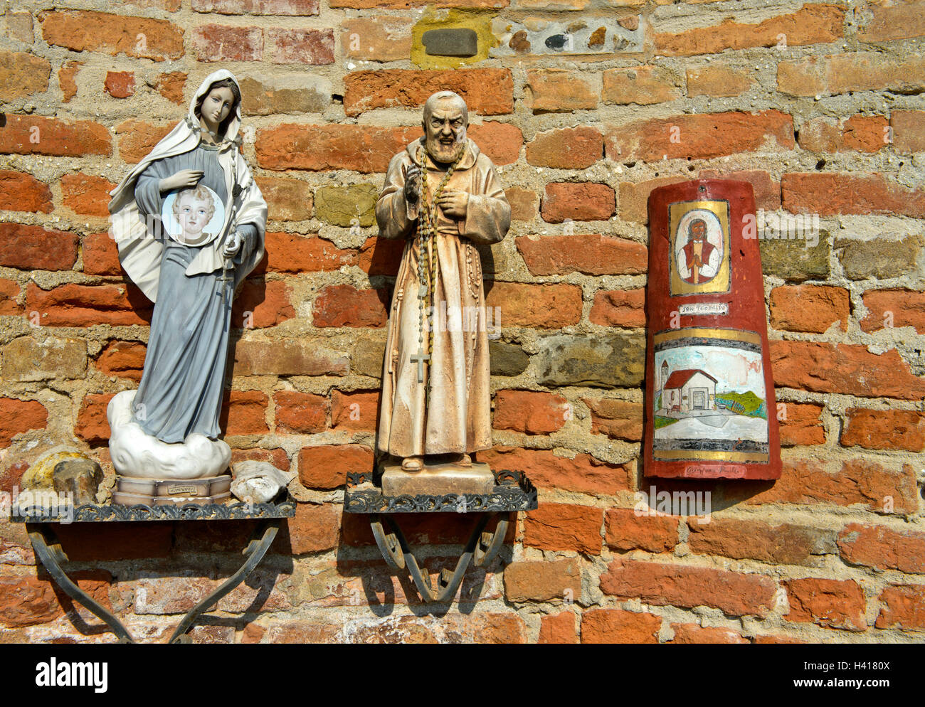 Statuen der Madonna und ein Mönch an der Kirche San Giovanni Battista, Barbaresco, Provinz Cuneo, Piemont, Italien Stockfoto