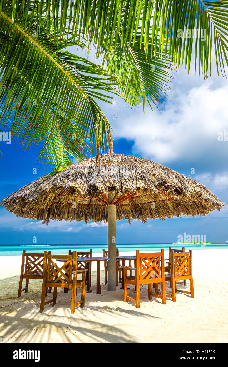 Tisch und Stühle im tropischen Strandrestaurant auf Malediven-Insel Stockfoto