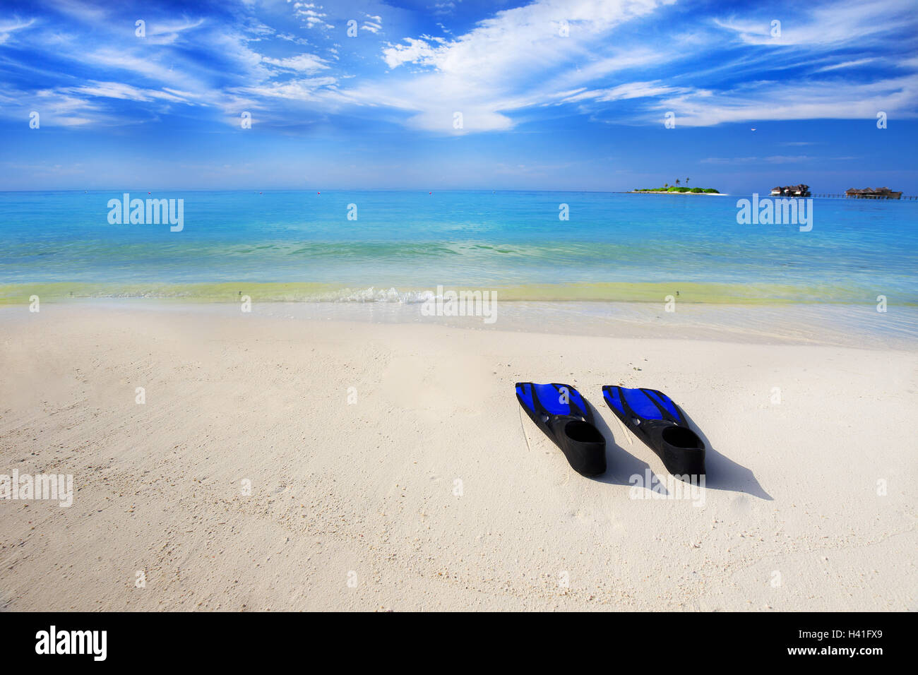 Tropischen Insel mit Sandstrand mit Wasserbungalows, Türkis klarem Wasser und Schnorchelausrüstung Stockfoto