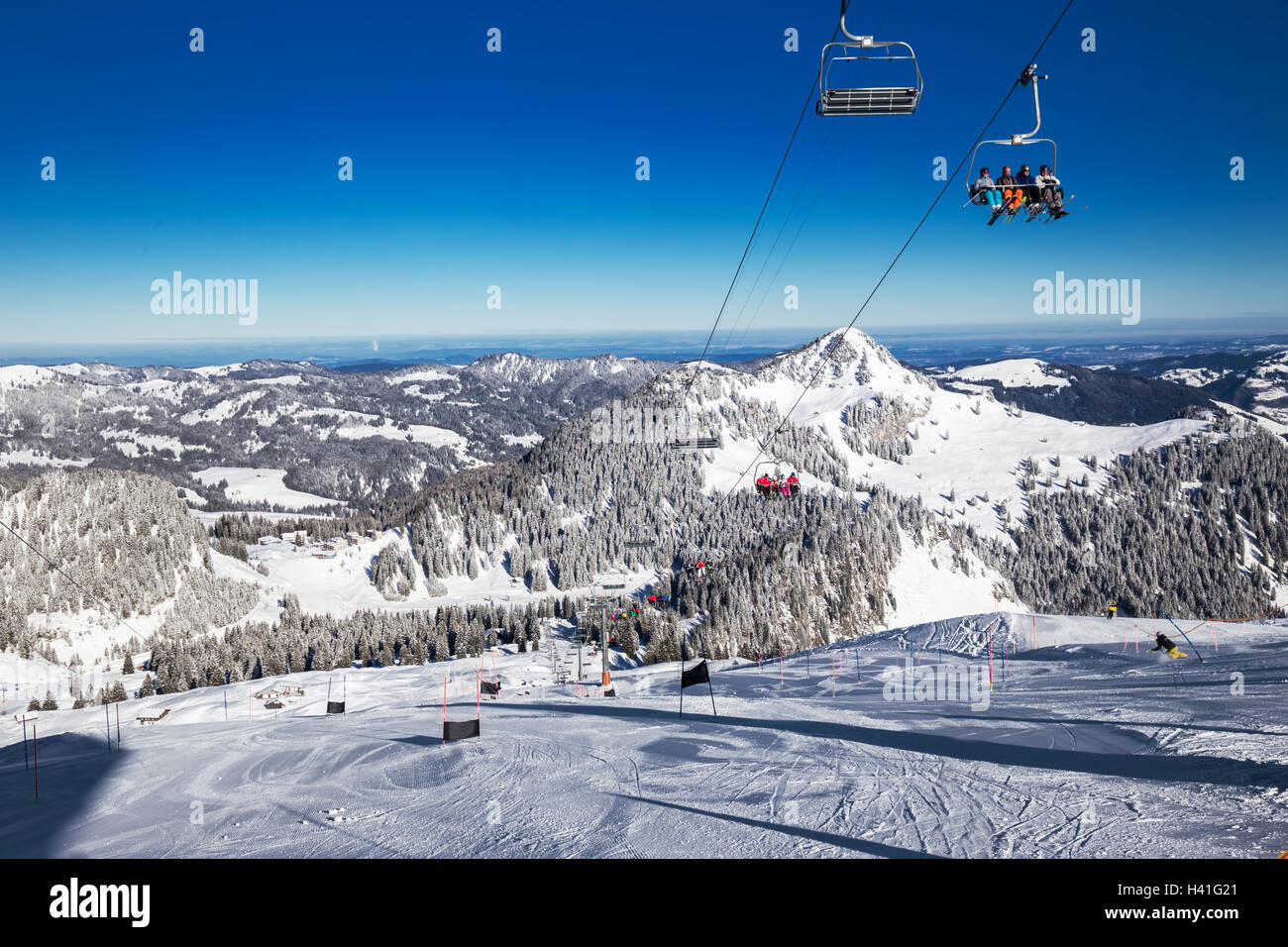 Skifahrer auf der Piste und Sessellifte, gesehen vom Skigebiet Hoch-Ybrig, Schweizer Alpen, Schwyz, Zentralschweiz Stockfoto