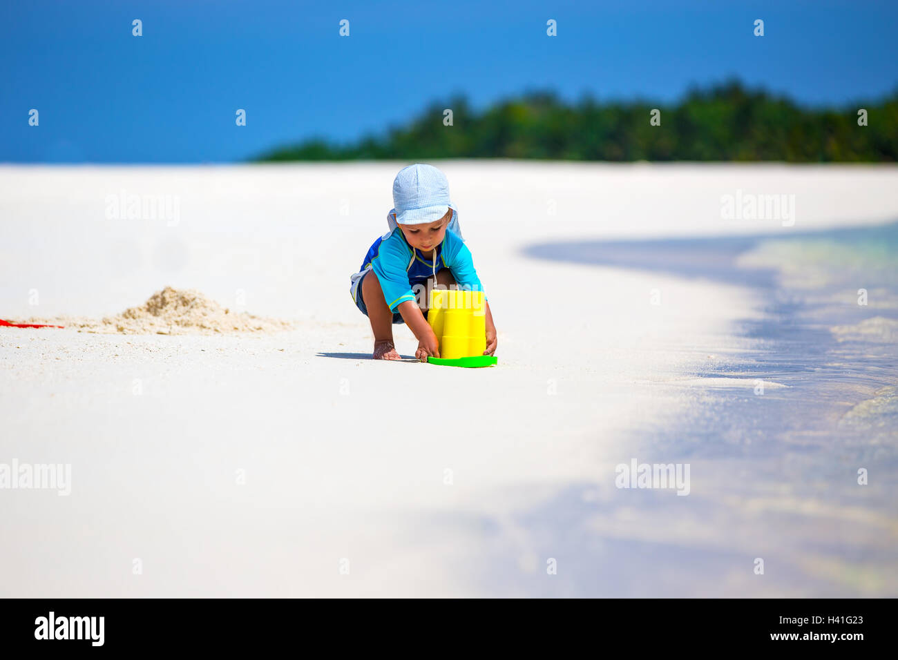 Kleinen Jungen Spaß am tropischen Strand eine Sandburg bauen Stockfoto