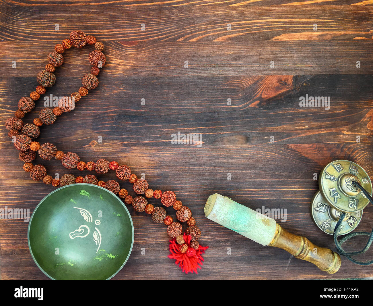 Singende Schüssel, Kupfer Schlagzeug Becken, Rudraksha Perlen für Meditation und Entspannung auf einem hölzernen braunen Hintergrund, Ansicht von oben Stockfoto