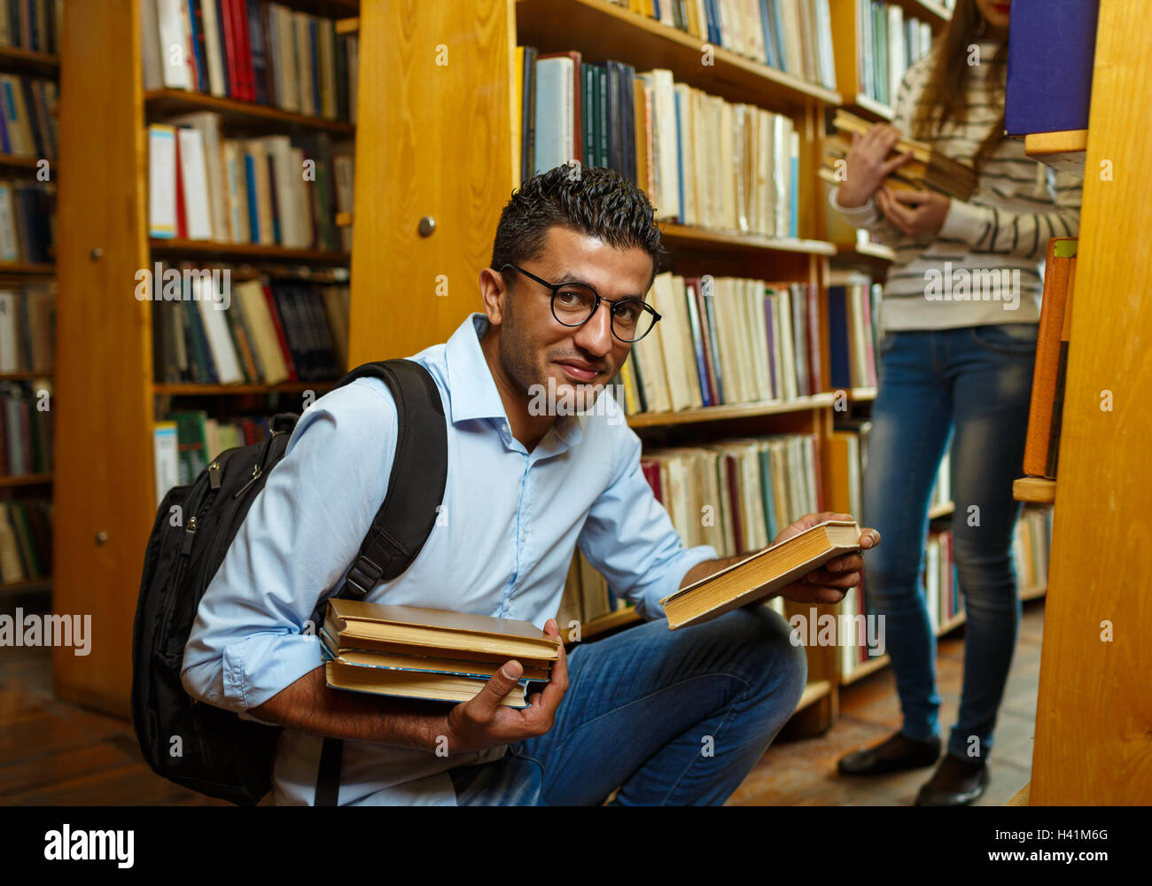 Junger Student paar Auswahl Bücher zwischen den Regalen in der Bibliothek Stockfoto