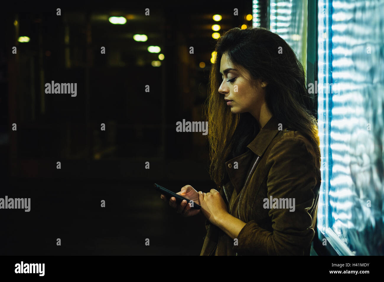 Frau stehend im Freien mit Handy Stockfoto