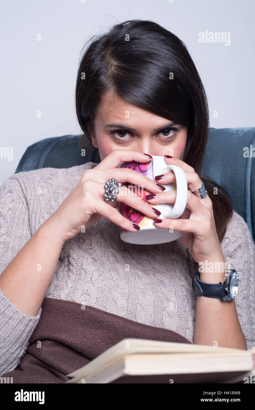 Frau trinkt Kaffee beim Lesen eines Buches Stockfoto