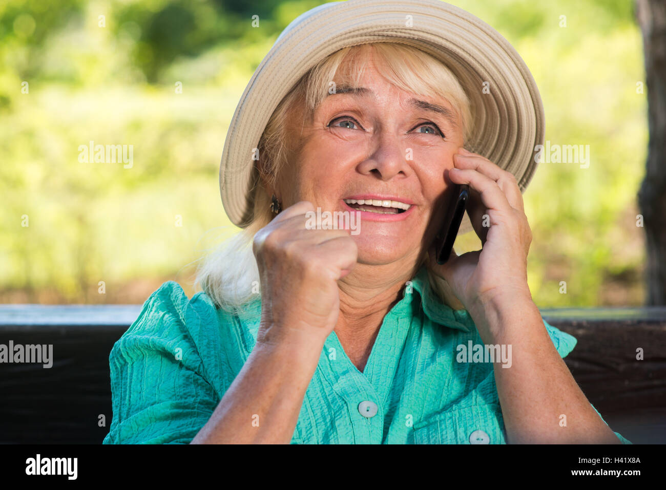 Glückliche ältere Frau mit Telefon. Stockfoto