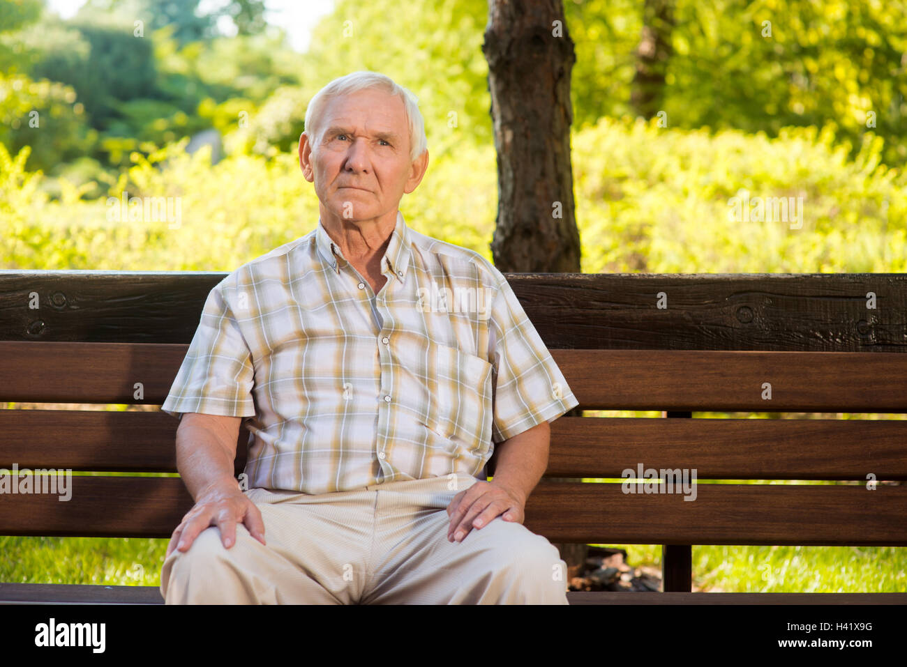 Alter Mann auf der Bank sitzen. Stockfoto