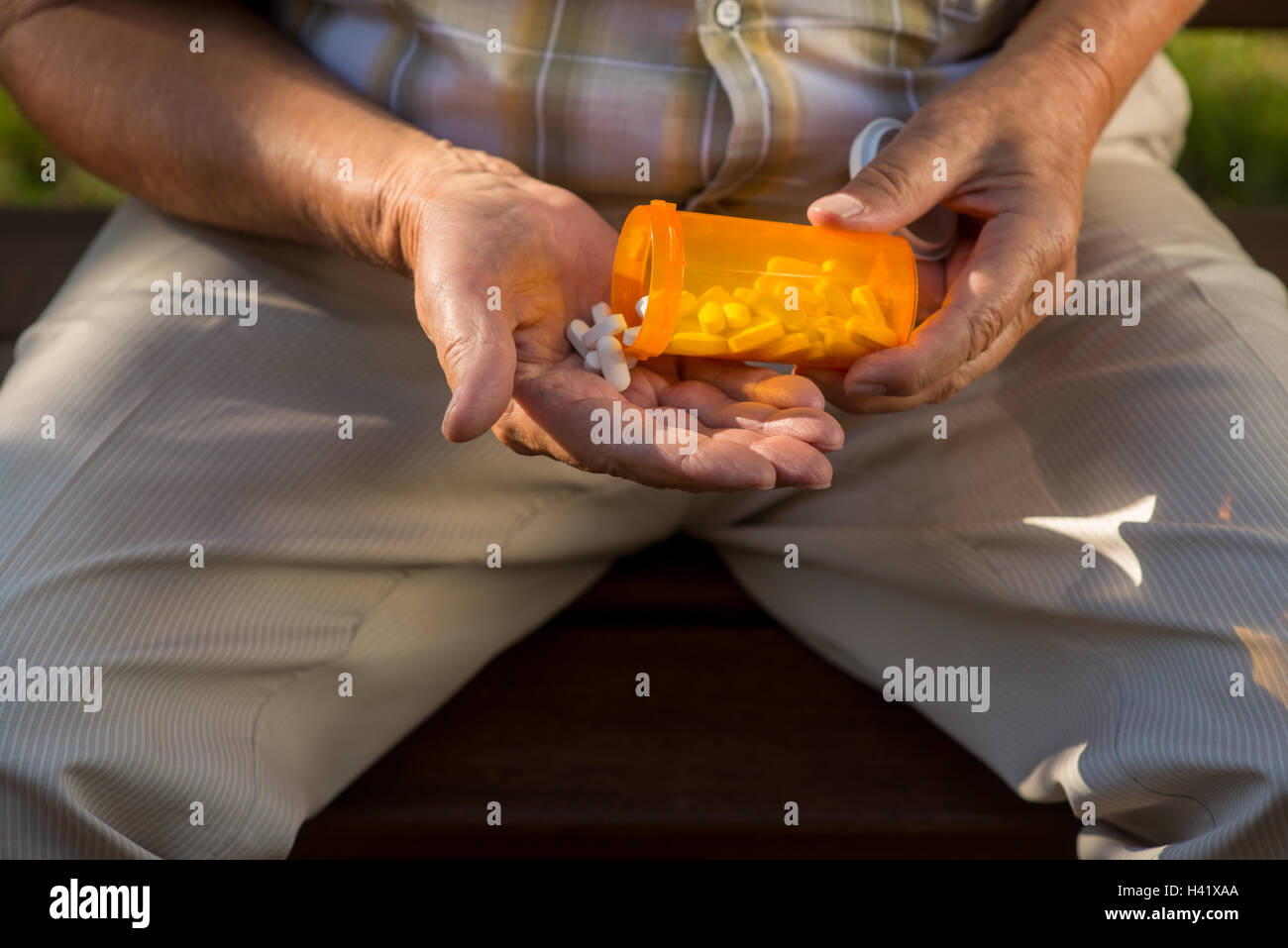 Ältere Hand hält weiße Pillen. Stockfoto