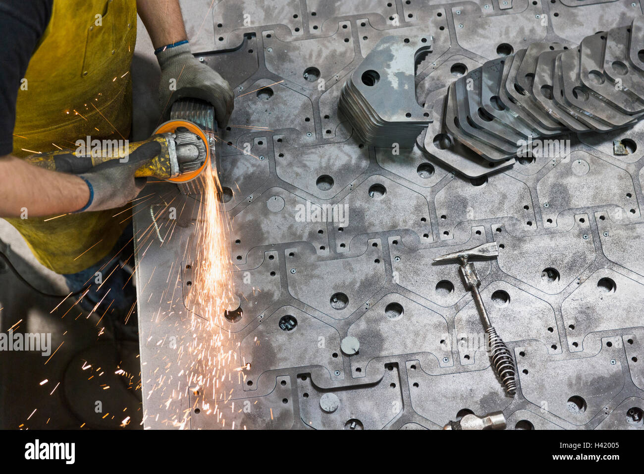 Kaukasische Arbeiter Schleifen Metall im Werk Stockfoto