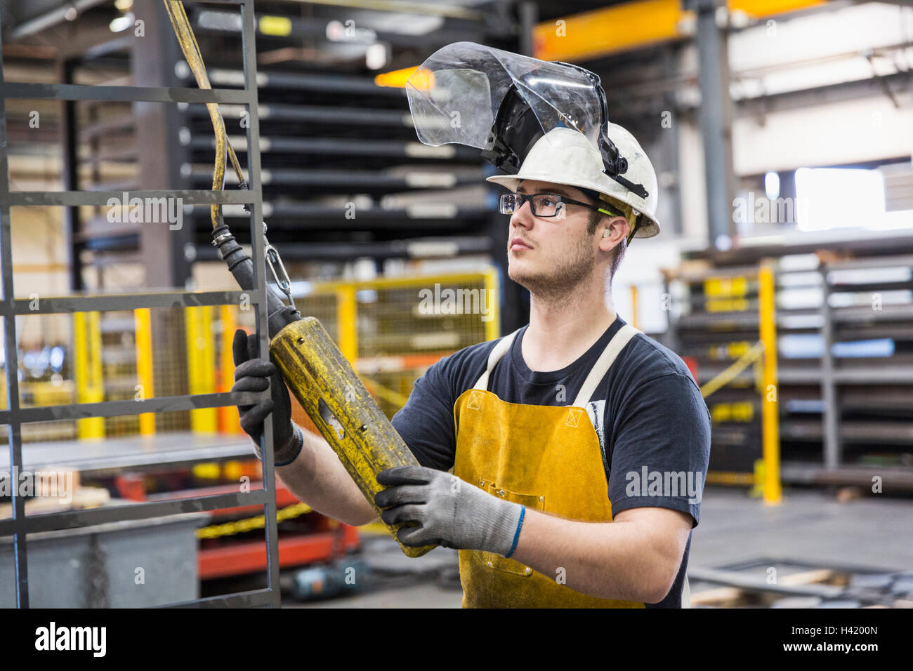 Kaukasische Arbeiter halten Controller in Fabrik Stockfoto