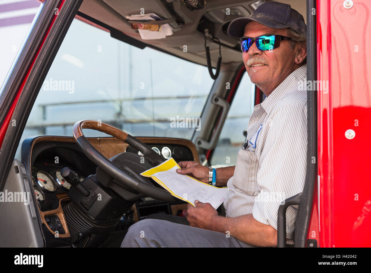 Kaukasische semi-LKW-Fahrer halten Papierkram Stockfoto