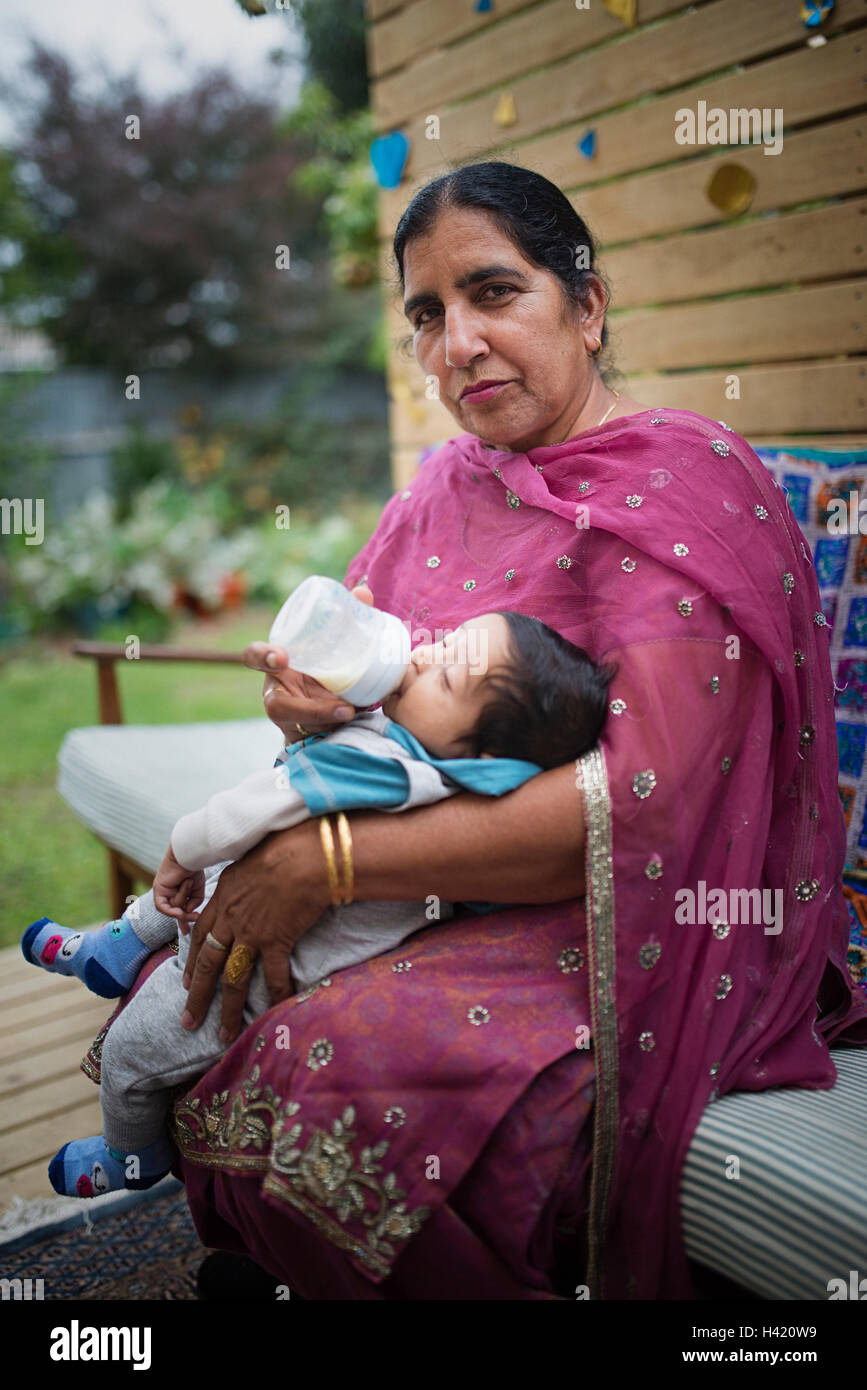 Indische Großmutter Babyflasche mit Enkel Stockfoto