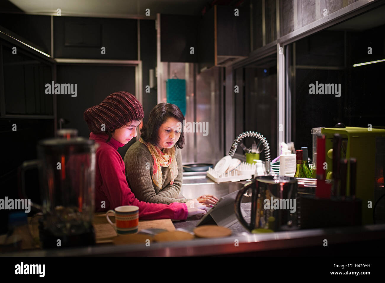 Mutter und Tochter mit digital-Tablette in Küche in der Nacht Stockfoto