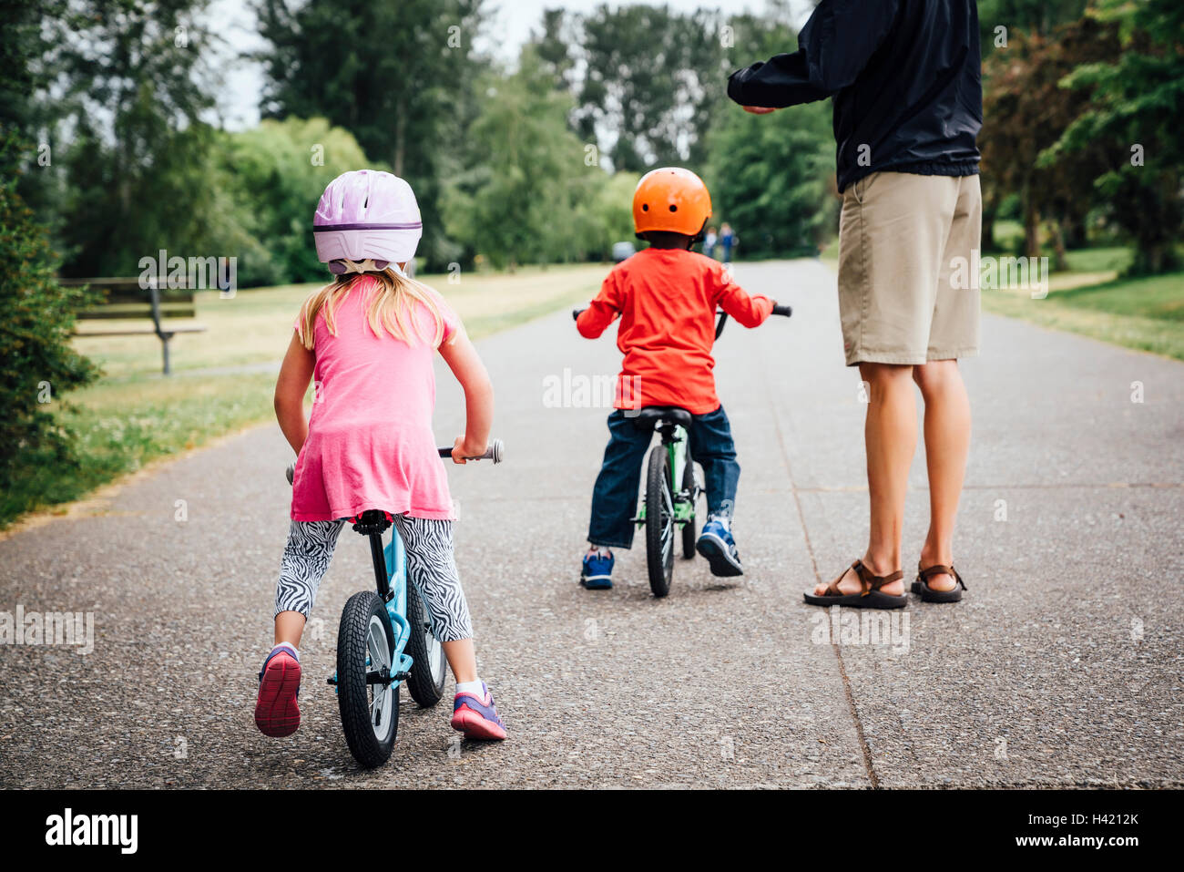 Vater beobachtete Tochter und Sohn Fahrrad fahren Stockfoto