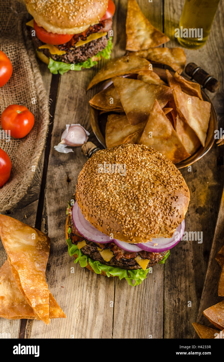 Amerikanische rustikale Speck Burger mit Cheddar, Rindfleisch, Salat und Gemüse, Old-School-Bild, mit tschechischem Bier und hausgemachte original Stockfoto