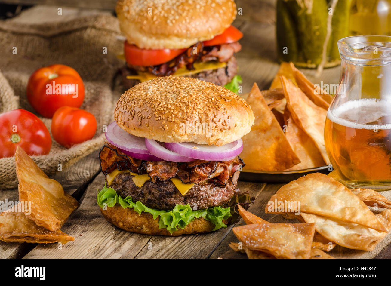 Amerikanische rustikale Speck Burger mit Cheddar, Rindfleisch, Salat und Gemüse, Old-School-Bild, mit tschechischem Bier und hausgemachte original Stockfoto