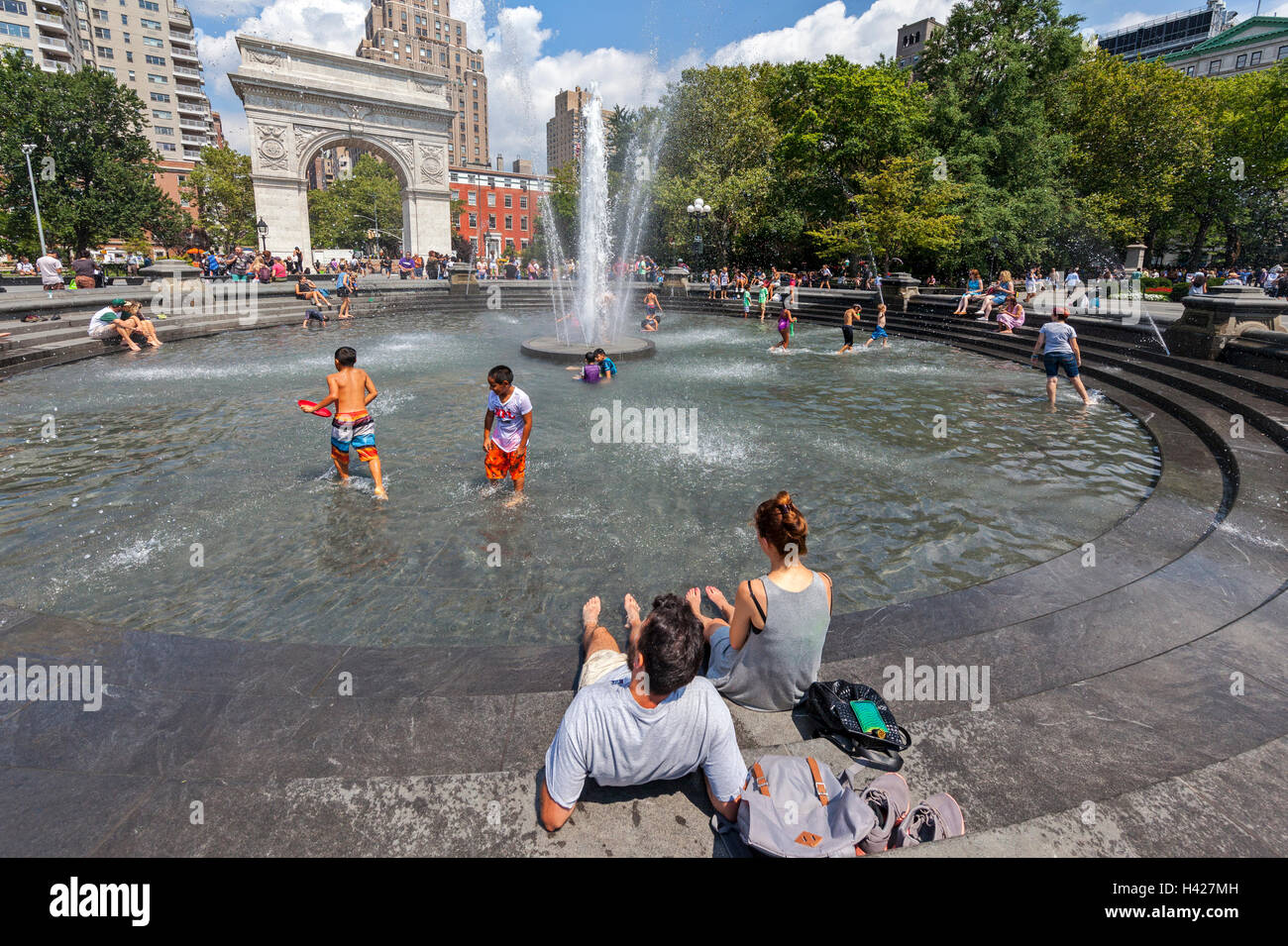 Washington Square Park Bogen in New York City und Menschen spielen in den Wasserbrunnen. Stockfoto
