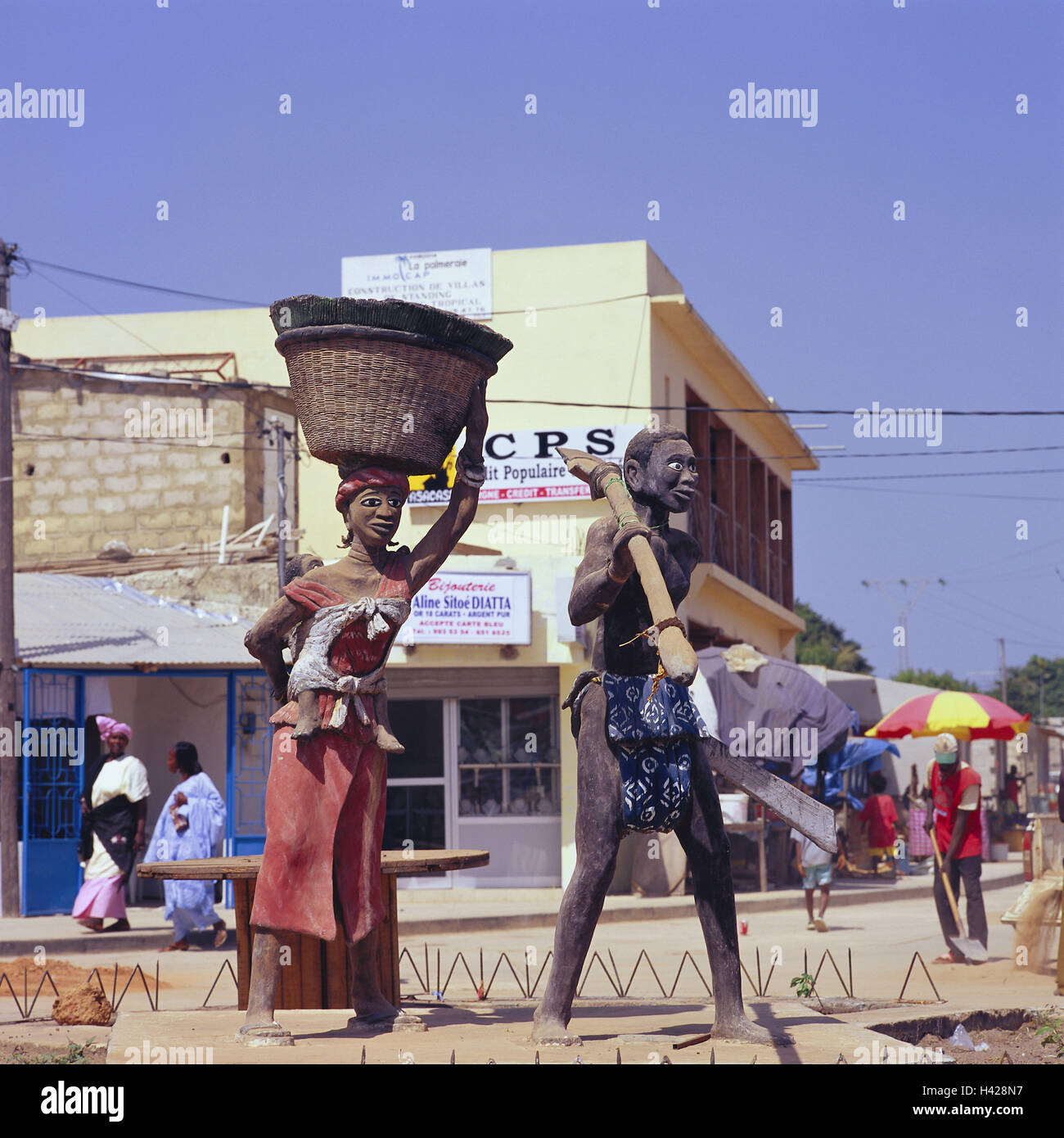 Senegal, Bass Casamance, Cap Skirring, Blick auf die Stadt, Diola Denkmal, Passanten, Afrika, West, Afrika, untere Casamance, Senegal, um Bass Casamance, Cap Skirring, Stadt, Straßenszene, Straße, Geschäfte, Läden, Skulptur, Denkmal, ethnische Gruppe, Stamm Diola, Diola paar, Symbol, Kunst, in der Regel, traditionell, Menschen, Senegalesen, dunkelhäutigen, Stockfoto