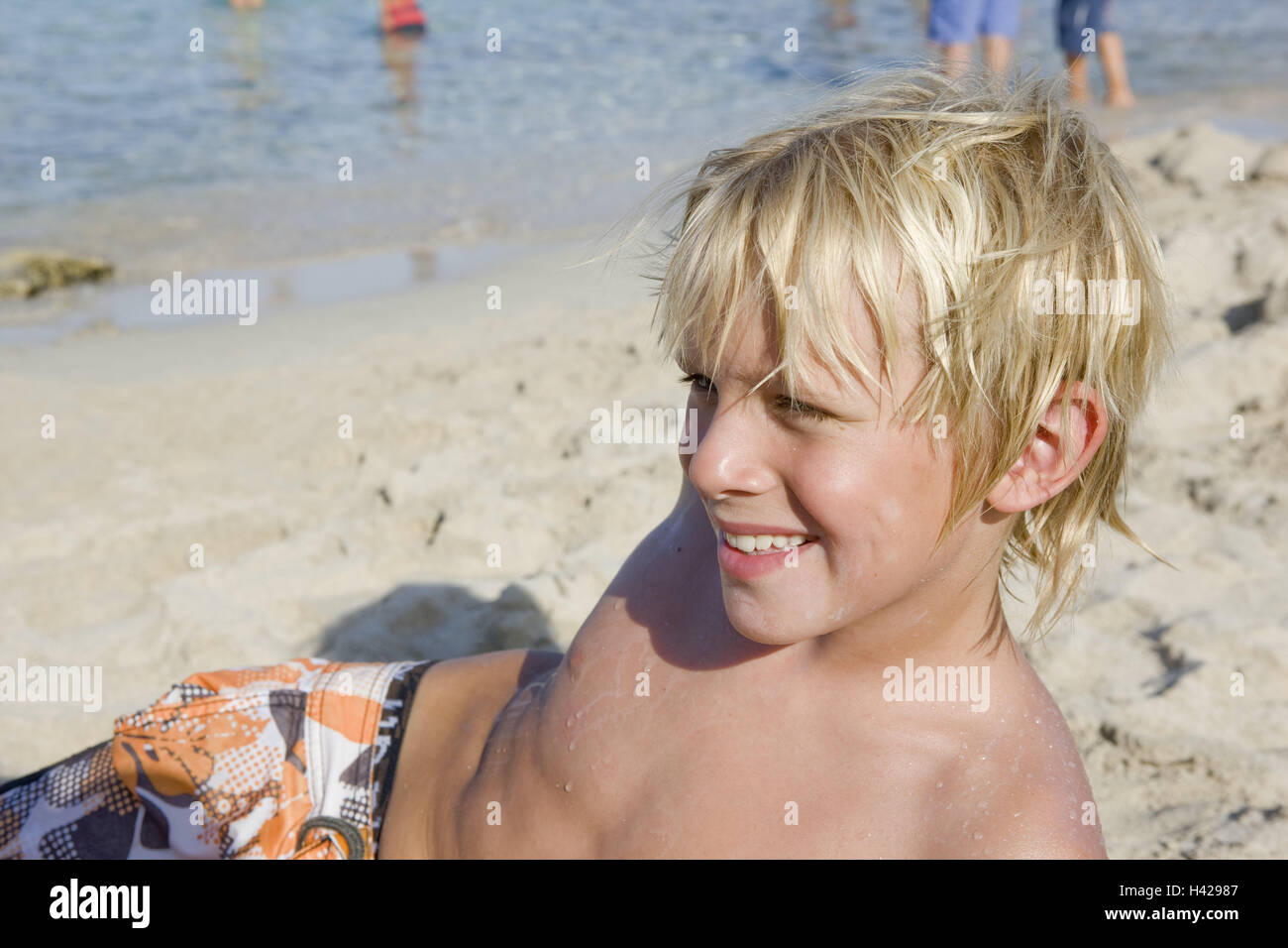 Strand, junge, Sand, Lüge, Porträt, Seitenansicht, Menschen, Kinder,  Sommerferien, Urlaub, Sonne, Wasser, Meer, Schwimmen, Badehose, Badehosen,  Shorts, sonnen sich, holen Sie braun, Blond, Lächeln Stockfotografie - Alamy