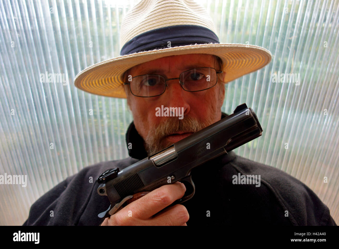 Eine kriminelle Bande Mitglied Gangster Räuber oder Straßenräuber zeigt eine automatische Pistole Colt 45 Stockfoto